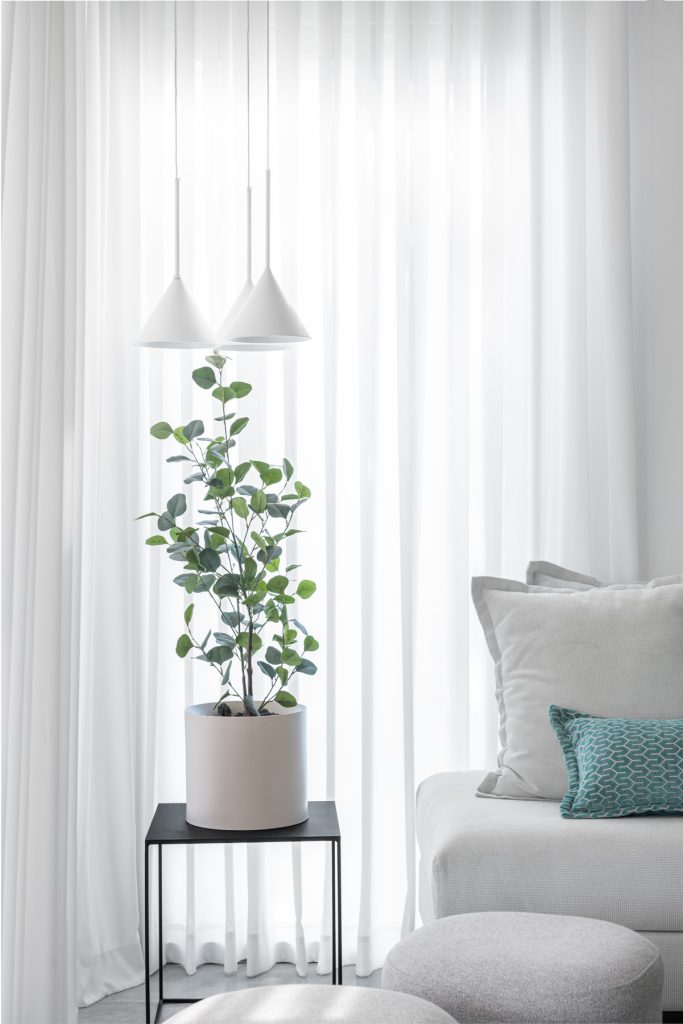 פינת ישיבה מעוצבת , עם צמח ותאורה בגוונים בהירים